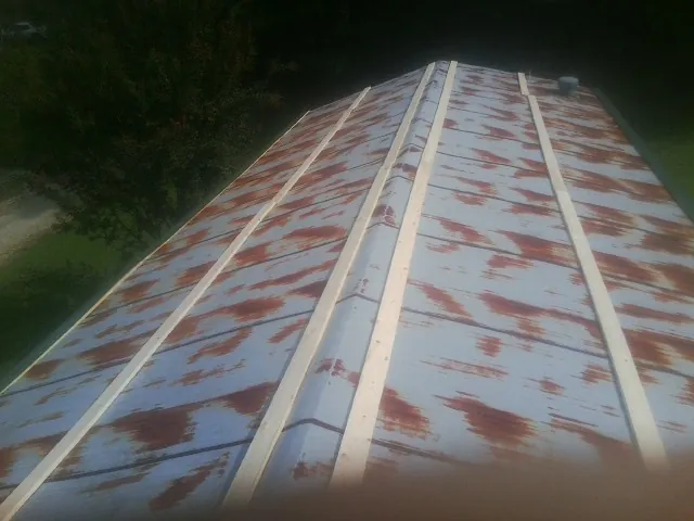 Rusted metal roof panels with new wood purlins before replacement — Storm Damage Roof Repair in Perkins by Roofing Brothers