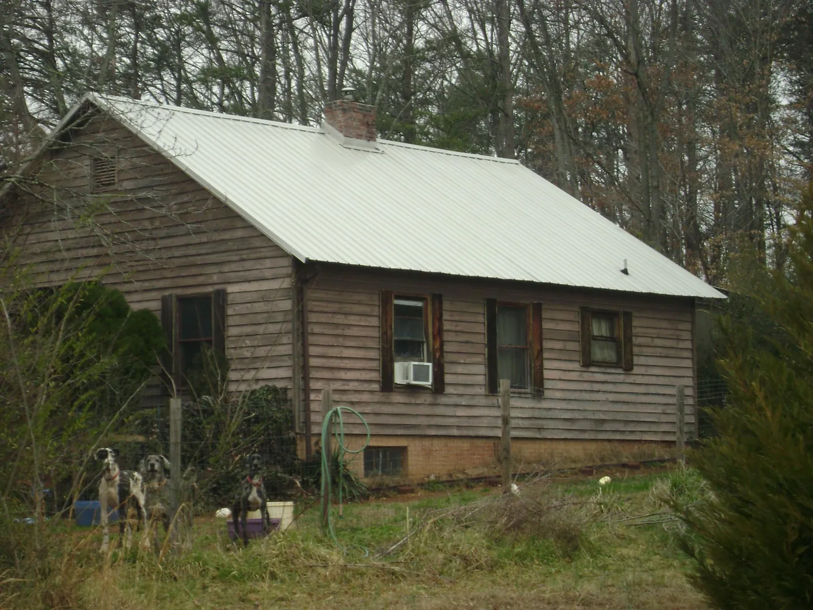 White metal roof on an old wood sided farmhouse, from a Metal Roof Installation job in Perkins